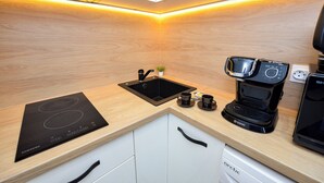 Una cocina moderna con placa de inducción integrada, cafetera y fregadero.