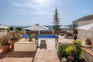 A rooftop pool area with a view of mountains, surrounded by potted plants and outdoor furniture. - Andalusia in the Heart (Cómpeta)