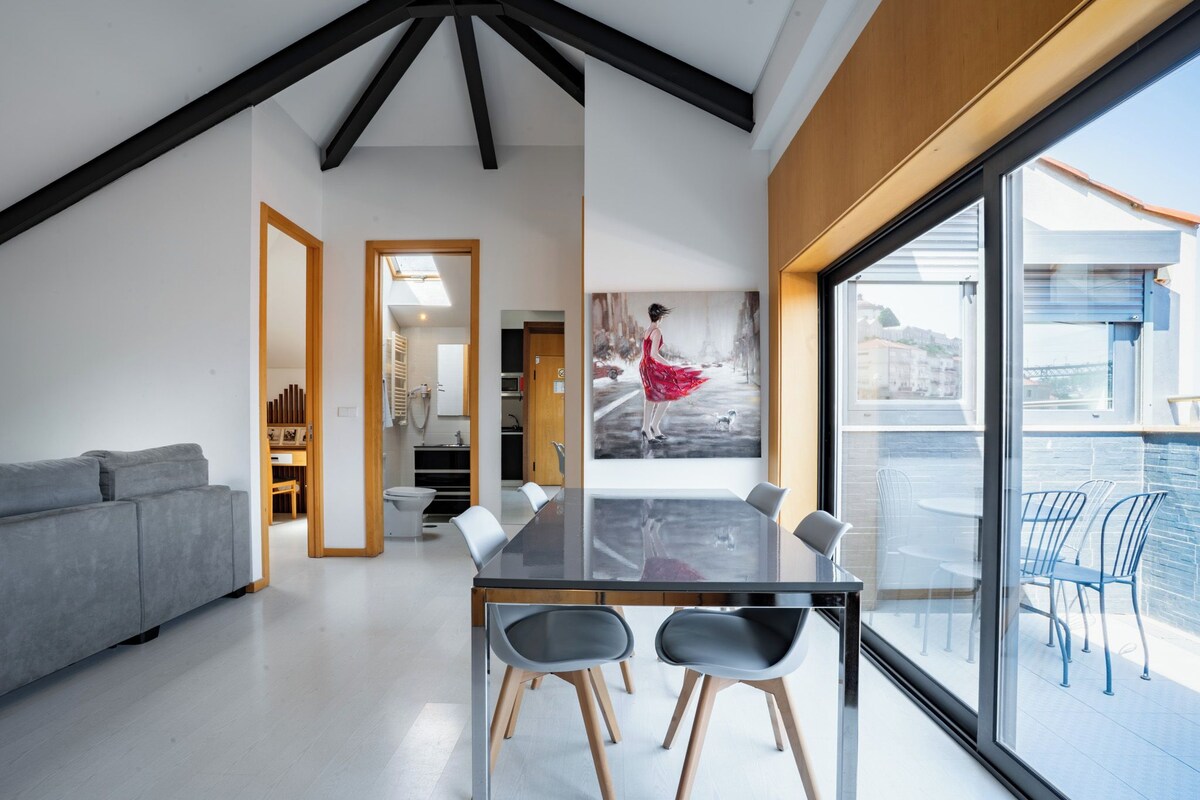 A modern interior with a dining table, chairs, a sofa, a large window, and a painting.
