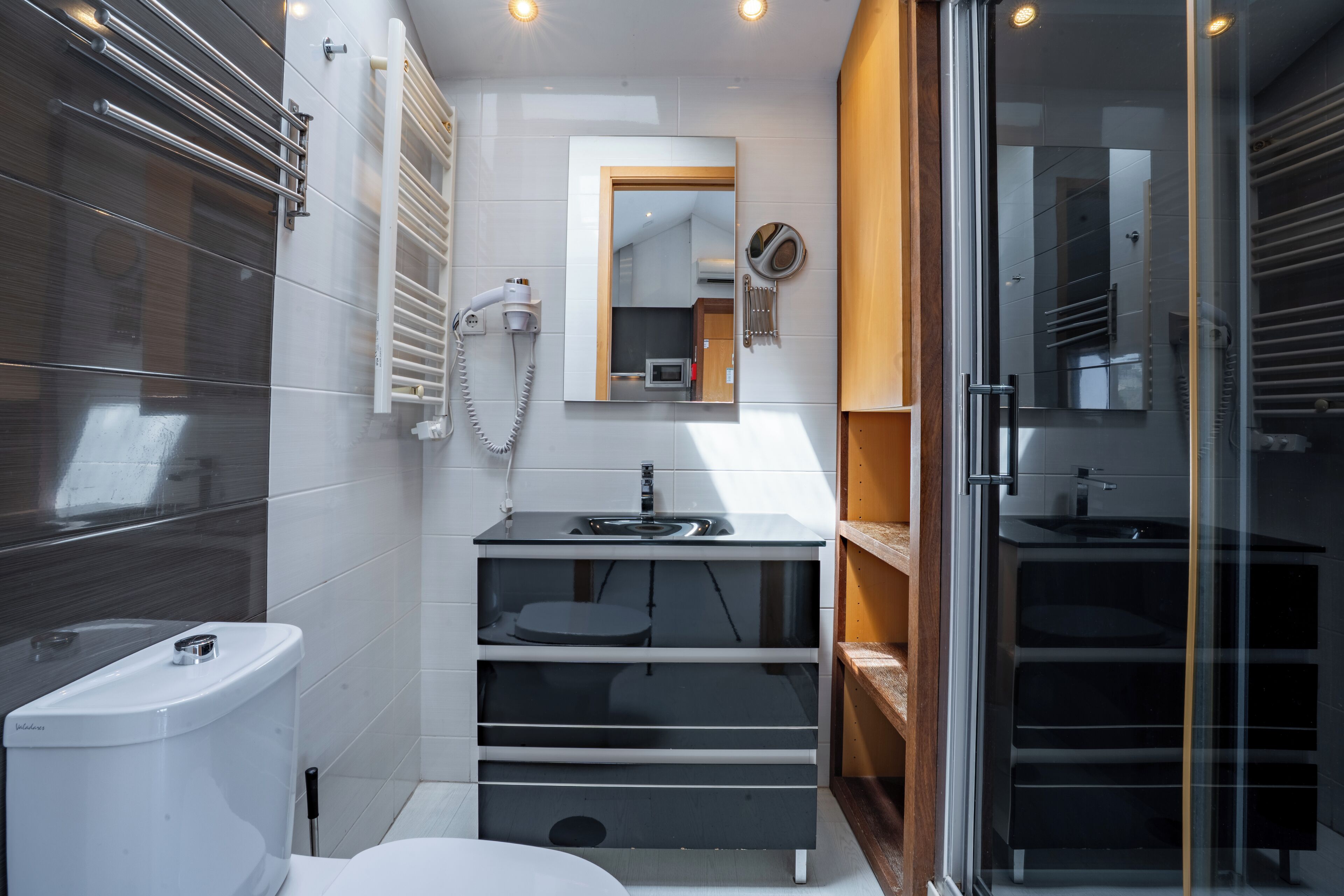 Ein modernes Badezimmer mit Toilette, Waschbecken und Duschkabine aus Glas.
