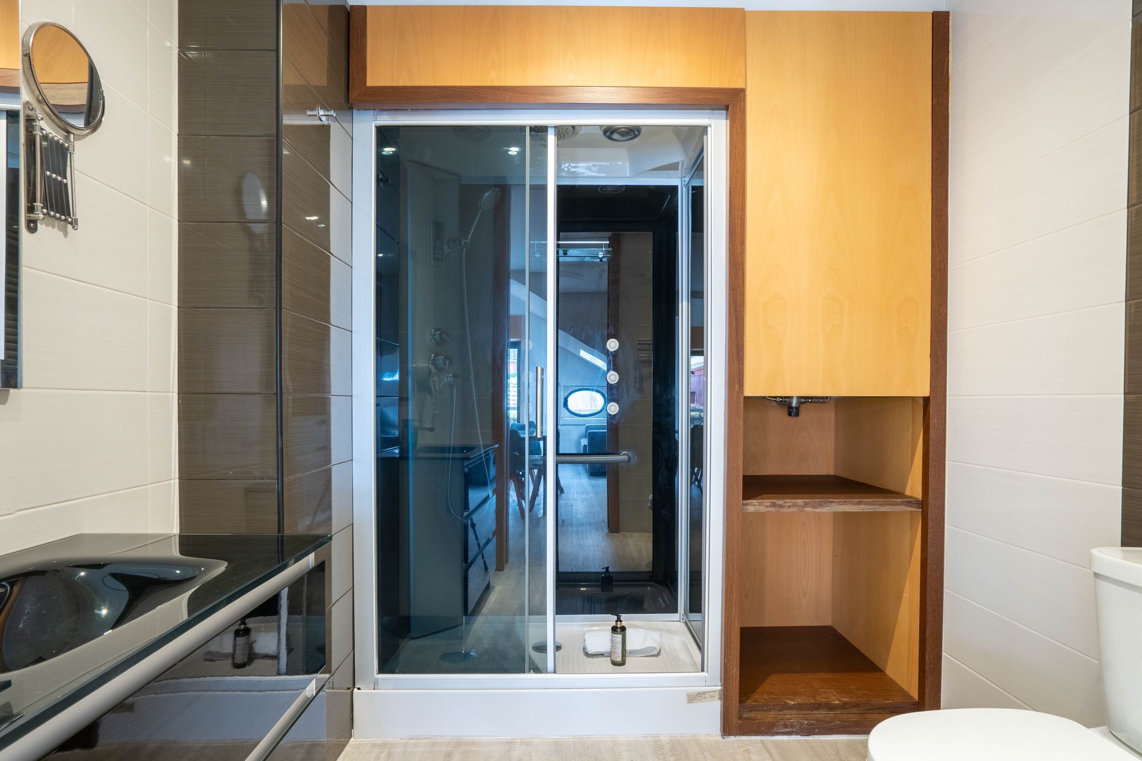 A modern bathroom with a glass-enclosed shower, a toilet, and a sink.