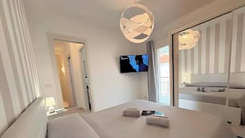 Een moderne hotelkamer met een groot bed, een flatscreen televisie aan de muur en een raam met uitzicht.