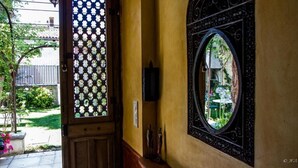Una porta con decorazioni a reticolo, una luce a parete e uno specchio decorativo.