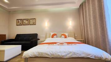 A hotel room with a bed, a sofa, and a desk.