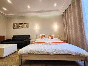 Relax in a stylish room with a large bed, sofa, and neutral decor.