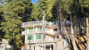Un edificio de varios pisos con balcones, una escalera y un letrero que indica 'Avenor Cottages'.