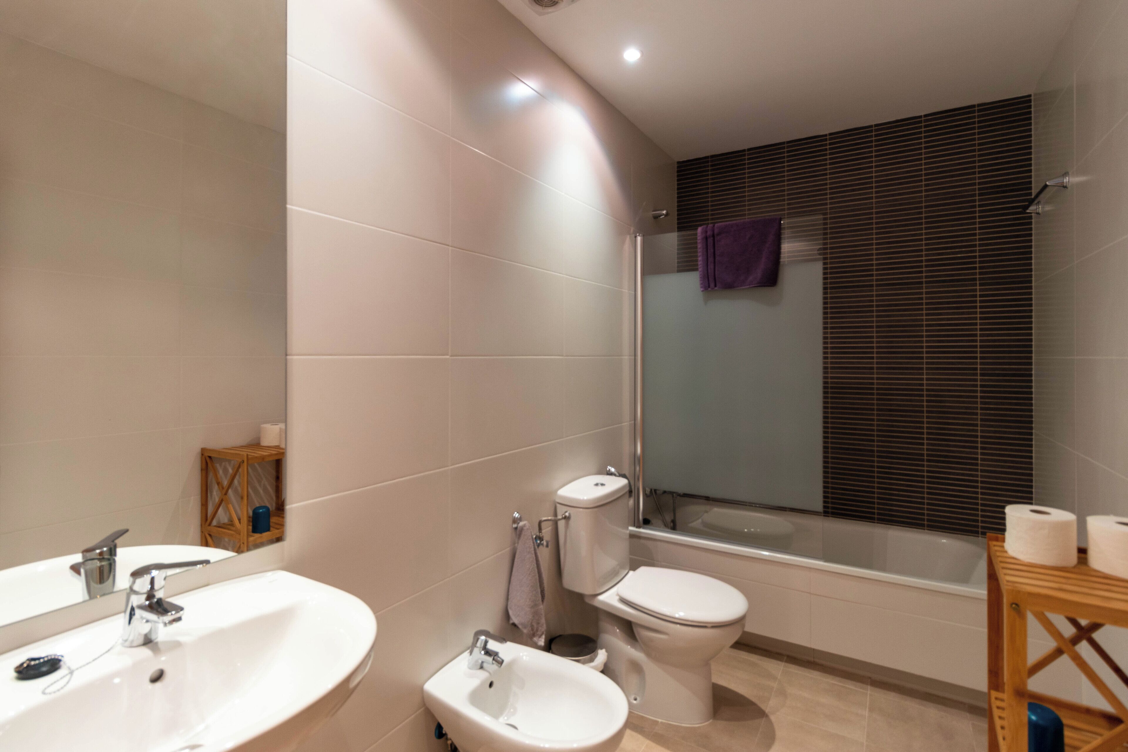 Un baño moderno con lavamanos, bidé, inodoro y bañera.