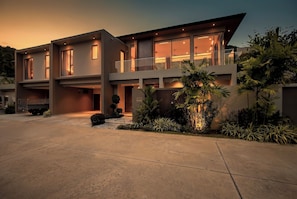 A modern two-story house with large windows, a balcony, and a well-maintained garden. - Stylish New Villa in Bang Tao, Phuket’s most luxurious area (Phuket)