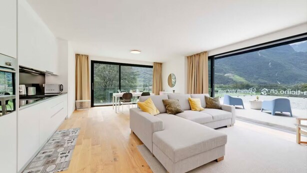 A modern living room with a sofa and a dining area. - An oasis of peace in nature (PPegasus 11 Residenza Ticino) (Bellinzona)