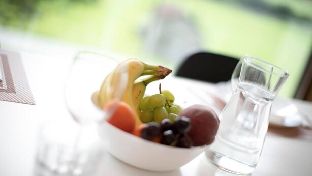A bowl of fruit on a table with a clear glass pitcher. - An oasis of peace in nature (Perseo 02 Residenza Ticino) (Bellinzona)