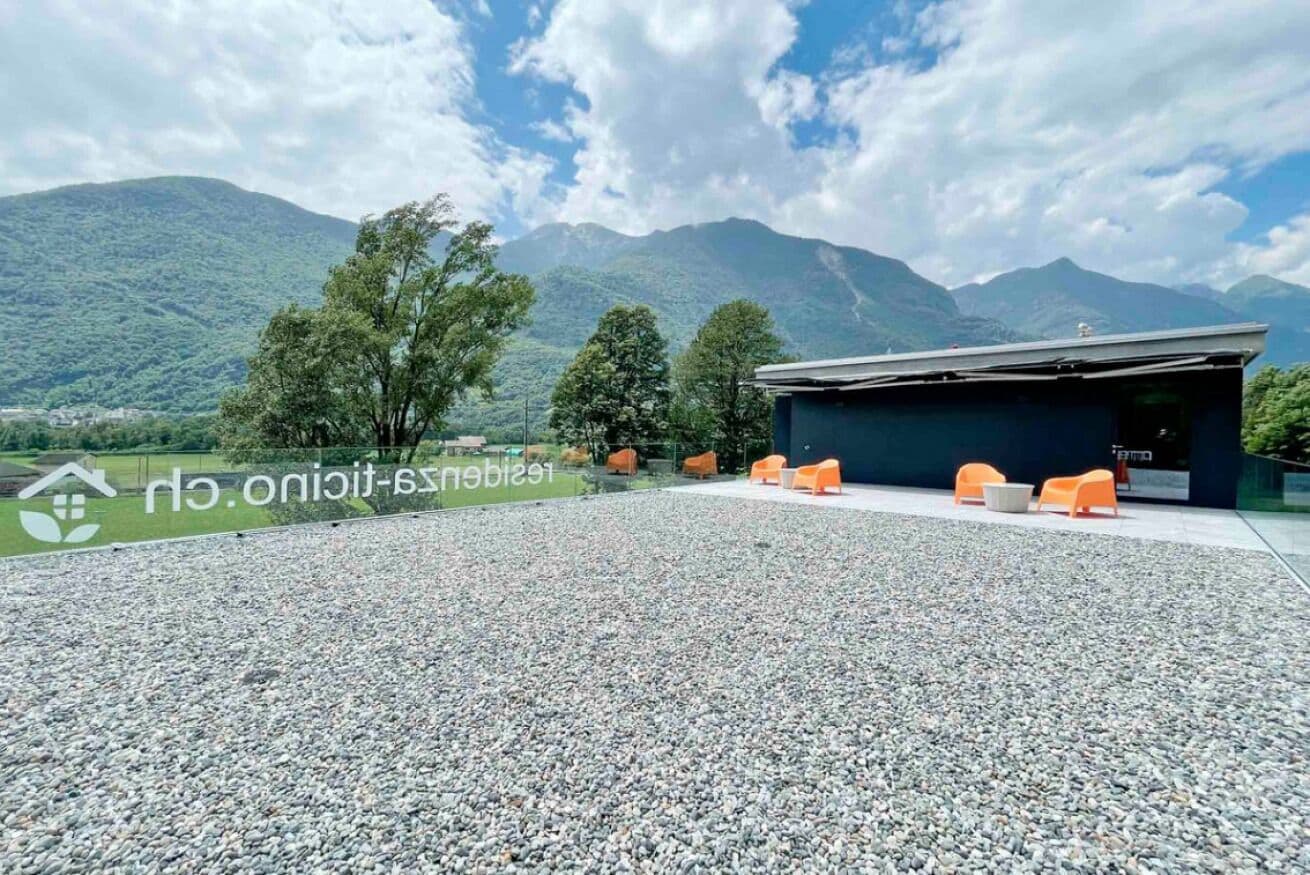 A building with outdoor seating and a view of mountains.