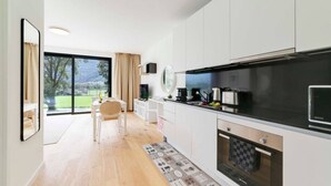 Eine moderne Küche mit weißen Schränken, einer schwarzen Arbeitsplatte und einem eingebauten Backofen.