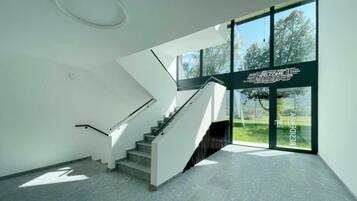 A modern interior with a staircase, large windows, and a welcoming sign.