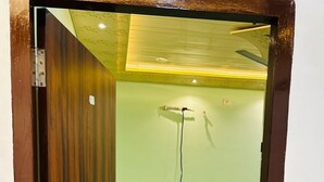 Une pièce avec une porte en bois, un lit, un ventilateur de plafond et un luminaire.