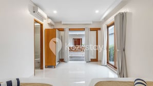 A hotel room with two beds, a large window, and a view of a balcony. - Amaya Villa by Kozystay - Canggu (Canggu)