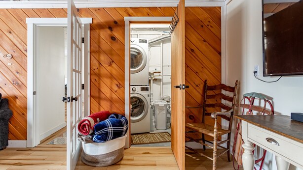 A laundry room with a washing machine, a drying rack, and a chair. - Ski Hike Lodge 5BR w Fire Pit Cozy Spaces (Maplecrest)