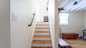 A wooden staircase leading to a door, a wooden bench, and a window with a curtain. - Ski Hike Lodge 5BR w Fire Pit Cozy Spaces (Maplecrest)
