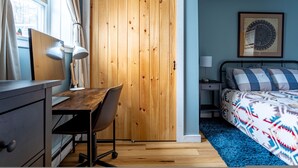 A bedroom with a wooden wardrobe, a desk with a chair, a bed with patterned bedding, and a framed artwork on the wall. - Ski Hike Lodge 5BR w Fire Pit Cozy Spaces (Maplecrest)
