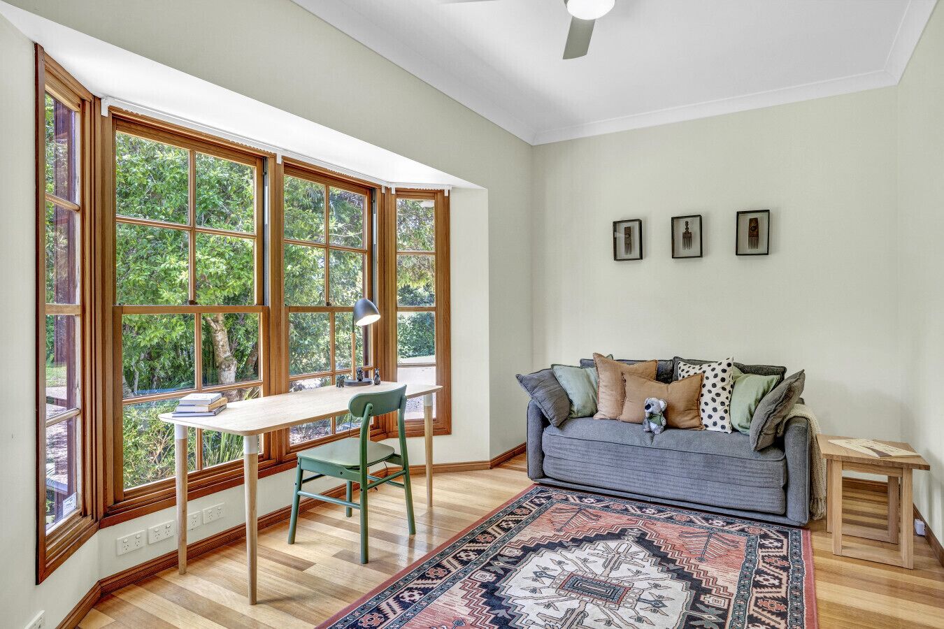 Une pièce comprenant un bureau, une chaise, un canapé et un tapis à motifs.