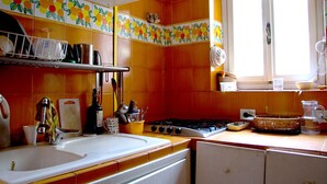 Une cuisine équipée d’un évier, d’une cuisinière et de divers ustensiles.