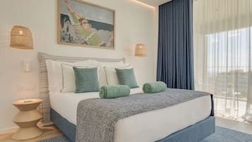 A modern hotel room with a large bed, two bedside lamps, a painting on the wall, and a view through sheer curtains.