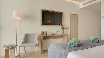 A hotel room with a bed, a desk, a chair, a TV, and a mirror.