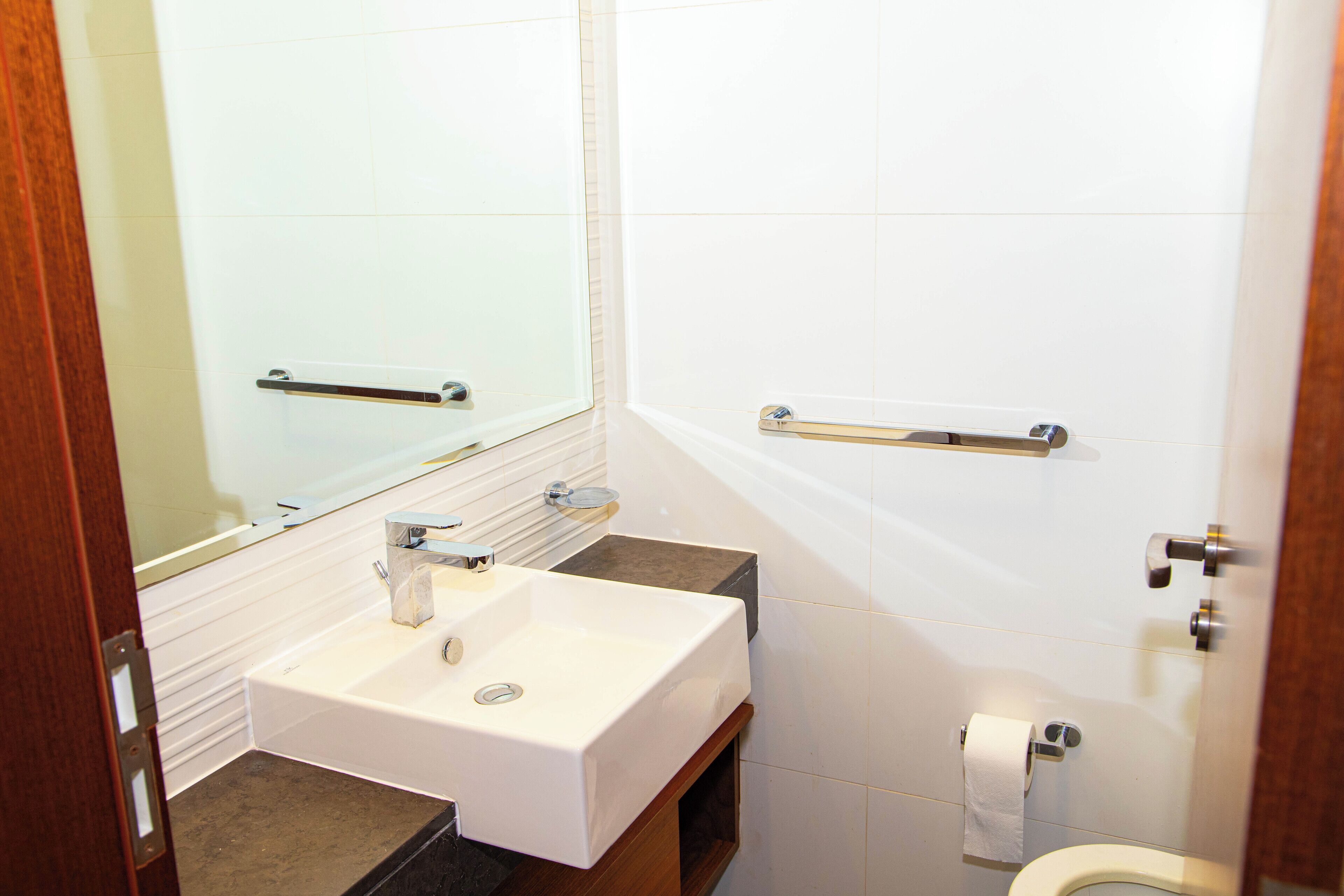 Ein Badezimmer mit Waschbecken, Spiegel und Toilette.