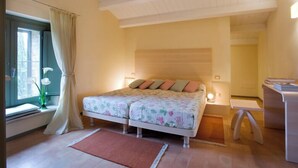 Una camera da letto con un letto matrimoniale, un comodino, una finestra con tende e una piccola lampada da comodino.