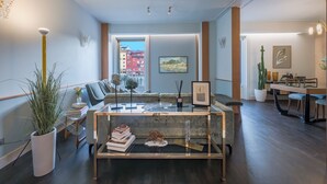 Un salon moderne avec une table basse en verre, un canapé et un coin repas comprenant une table et des chaises.