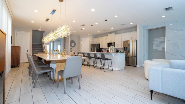 A modern kitchen with a central island, bar stools, and contemporary appliances.