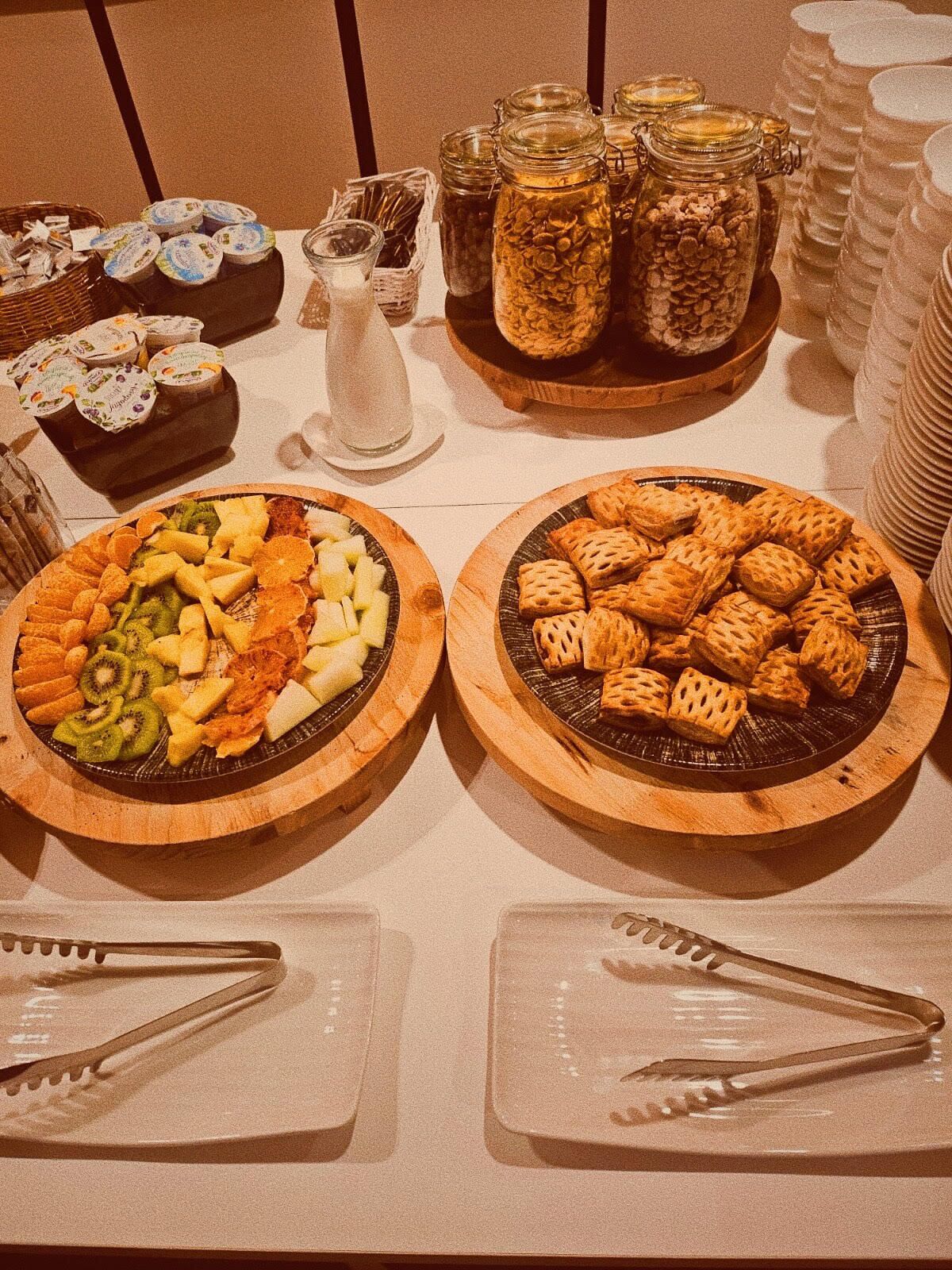 A buffet table with various food items and condiments.