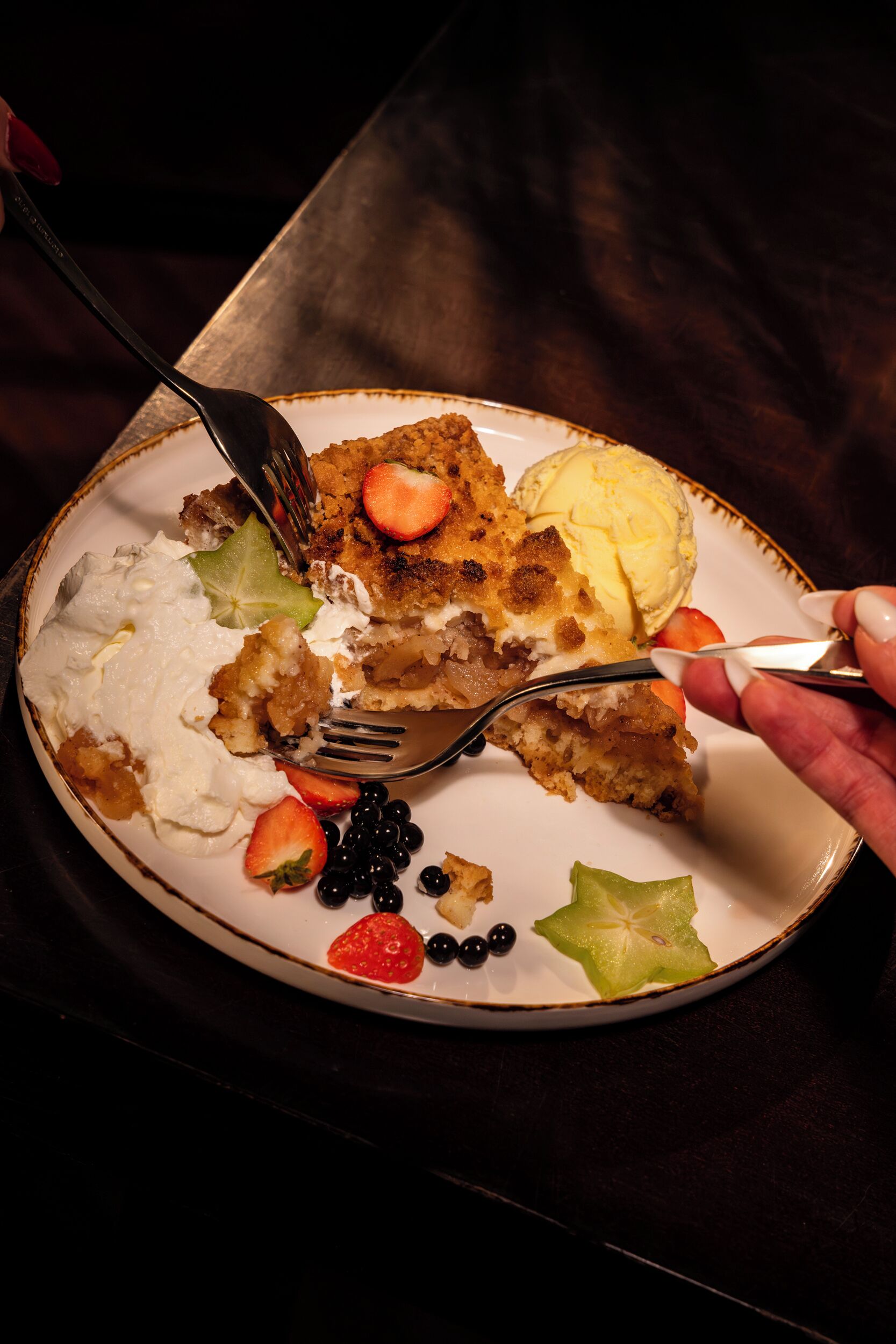 Un piatto con cibo, tra cui una fetta di torta, gelato e frutta.