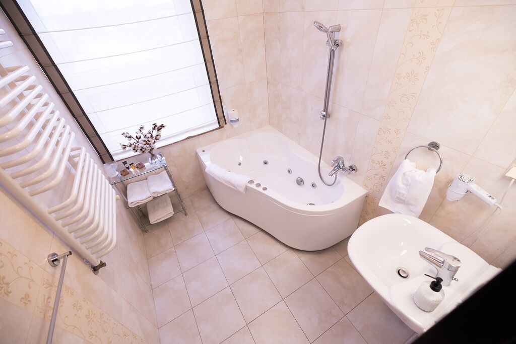 A modern bathroom with a freestanding bathtub, a separate sink, and a glass shower enclosure.