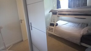 A bunk bed with a ladder, a white wardrobe, and a door. - 5 Guests - Pet Friendly - Balcony & Free Parking (Dartford)