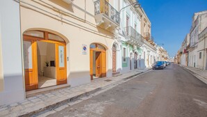 A street with buildings featuring arched doorways and balconies.