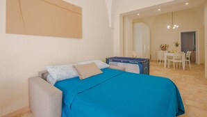A bedroom with a bed, a desk, and a chair.