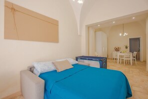 Een slaapkamer met een bed, een bureau en een stoel.