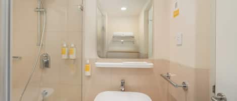 A modern bathroom with a shower, sink, and mirror.