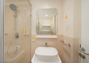 A modern bathroom with a shower, sink, and mirror.