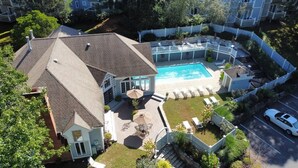 A residential property with a swimming pool, outdoor seating, and a fenced yard.