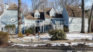 A two-story house with a front porch and a staircase leading to the second floor.