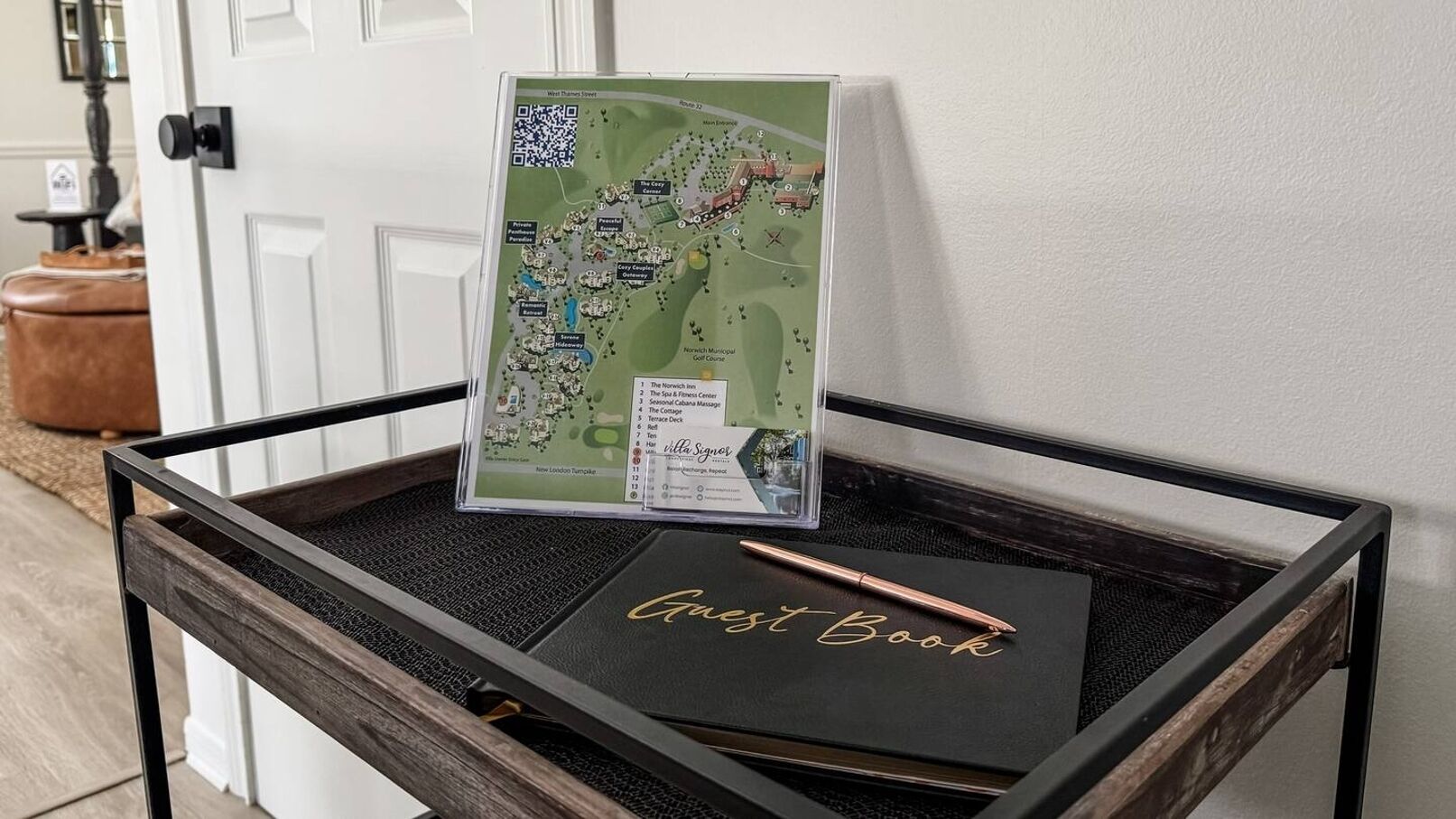 Uma bandeja de madeira com um livro de visitas e um mapa de um campo de golfe.