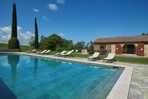 Una piscina techada, una piscina al aire libre de temporada, sombrillas