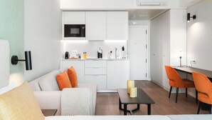 A modern, compact living space with a kitchenette, a dining area, and a seating area. -  Limehome Lisbon Campo Pequeno (Lisbon)