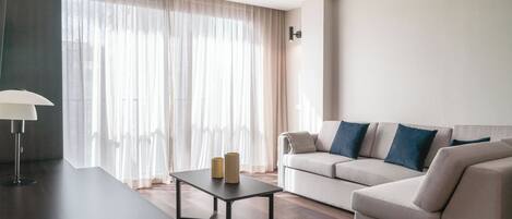 Uma sala de estar moderna com um sofá, uma mesa de centro e uma luminária.