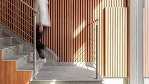 A staircase with a wooden slatted wall and a metal railing. -  Limehome Lisbon Campo Pequeno (Lisbon)