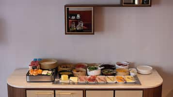 Una mesa de buffet con distintos alimentos y acompañamientos.