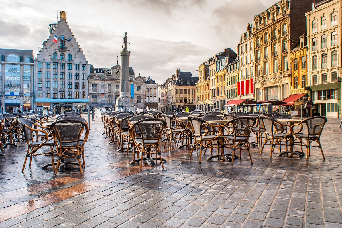 Une place historique, ornée d’un monument remarquable, bordée de bâtiments de style européen traditionnel et dotée d’espaces de détente en plein air.