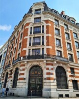 Un edificio histórico con una entrada destacada, ventanas amplias y ubicación en esquina.