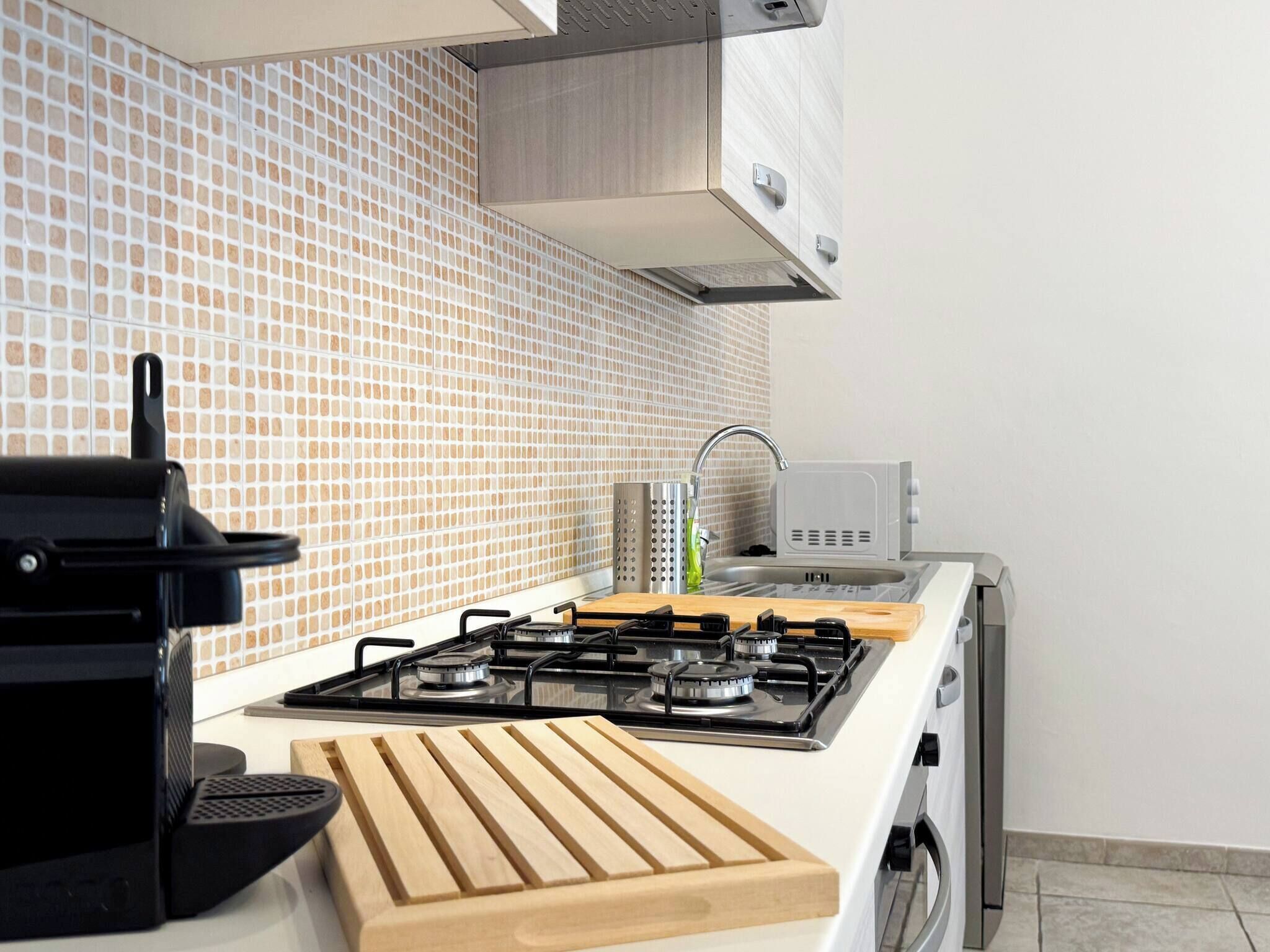 Una cocina con estufa a gas, microondas y pileta.